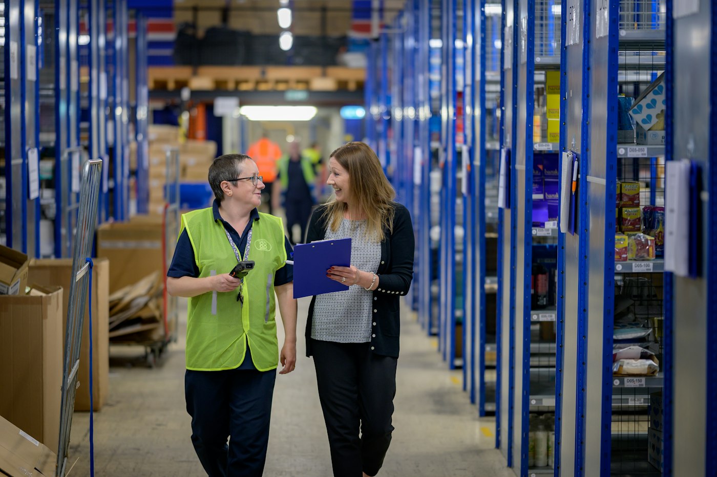 Warehouse team checking stock between racking aisles